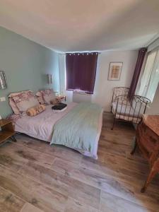 ein Schlafzimmer mit einem Bett, einem Stuhl und einem Tisch in der Unterkunft Rez de chaussée villa avec piscine in Piana