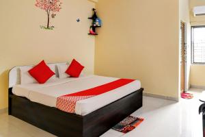 1 dormitorio con 1 cama con almohadas rojas en OYO Flagship Royal A Palace, en Bhubaneshwar