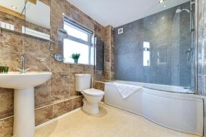 a bathroom with a tub and a sink and a toilet at Morgan House- 4 Bed House, Near Nottingham Trent Uni in Nottingham