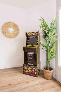 a video game machine sitting next to a potted plant at Maison indépendante au Croisé Laroche in Marcq-en-Baroeul