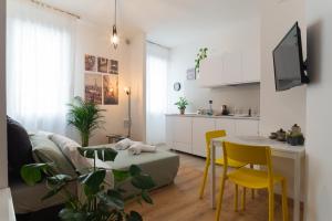 a kitchen and living room with a table and yellow chairs at Lombardi House in Treviso