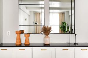 La salle de bains est pourvue d'un miroir et de vases sur un comptoir. dans l'établissement 73-208 New 2BR 2BATH UWS Doorman Gym, à New York