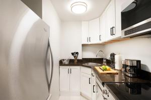 a kitchen with white cabinets and a stainless steel refrigerator at 73-208 New 2BR 2BATH UWS Doorman Gym in New York