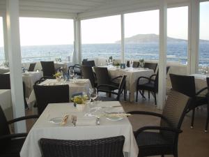 a restaurant with tables and chairs with the ocean in the background at Tempo Di Mare in Favignana