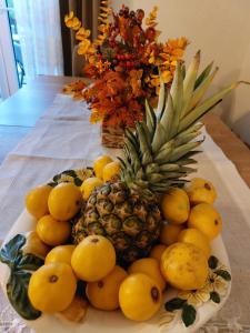 un plato de fruta en una mesa con una piña y naranjas en Kuća za odmor Iva, en Lič