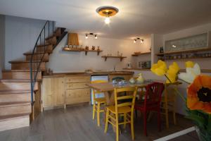 een keuken met een tafel en stoelen en een trap bij Casa Antonia 