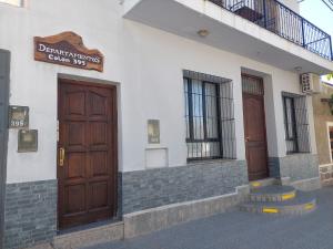 a building with a door and a sign on it at KAKAN cómodo apartamento 1 dormitorio in Cafayate