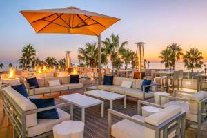 een patio met banken en tafels en een parasol bij SpringHill Suites by Marriott San Diego Carlsbad in Carlsbad