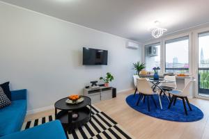 a living room with a blue couch and a table at Bella Luna Luxury Suites - Oasis Gem Near Stadium & Old Town in Warsaw