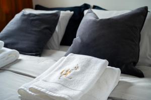 a bed with white towels and black pillows at Bella Luna Luxury Suites - Oasis Gem Near Stadium & Old Town in Warsaw