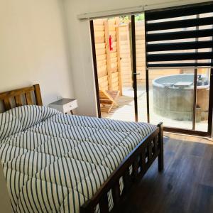 a bedroom with a bed and a sliding glass door at Lodge Liquitay in Hijuelas