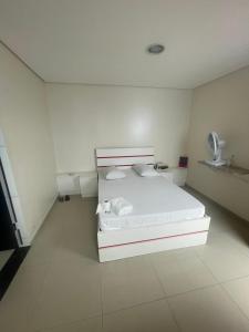 ein weißes Schlafzimmer mit einem Bett in einem Zimmer in der Unterkunft Hotel Kiss Sapopemba in São Paulo