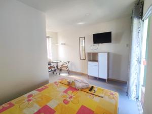 ein Schlafzimmer mit einem Bett und einem TV an der Wand in der Unterkunft MAU Suite&Apartment in Máncora