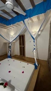 1 dormitorio con 1 cama con dosel azul y blanco en Stonefish Inn Jambiani, en Jambiani