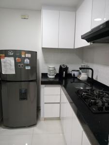 een keuken met een koelkast en een fornuis bij Apartamento cerca al Centro comercial Nuestro Cartago in Cartago