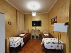 a room with two beds and a flat screen tv at San Pietro Chic in Rome
