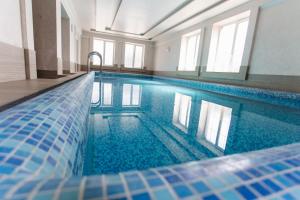 a swimming pool with blue tiles in a building at Hotel Kopa - Zhovkva in Zhovkva