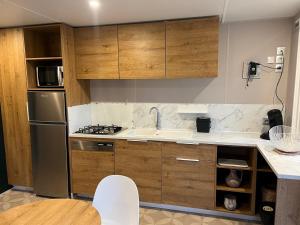a kitchen with wooden cabinets and a stainless steel refrigerator at Rent Paradise in Grimaud