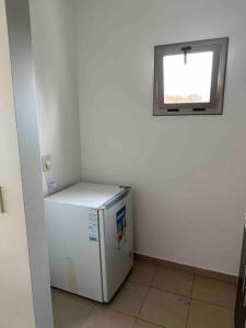 um pequeno frigorífico num quarto com uma janela em Departamento en Merlo Centro em Merlo