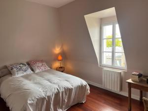 a bedroom with a white bed and a window at L'ART in Chantilly