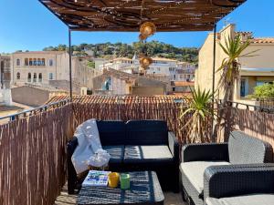 a patio with two chairs and a table on a balcony at ''Rooftop'' Superbe T3 quartier haut avec Rooftop privé! in Sète