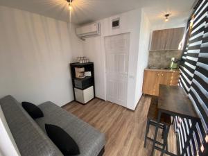 a living room with a couch and a table and a kitchen at Valea Regilor Happy Camp in Blidireasa