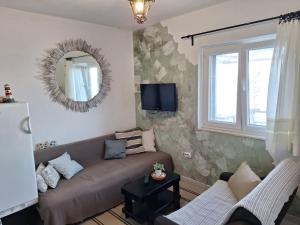 a living room with a couch and a mirror at Beach House Hvar in Zastražišće