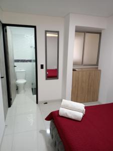 een badkamer met een rood bed en een toilet bij Apartamento cerca al Centro comercial Nuestro Cartago in Cartago