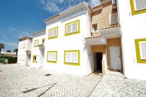 una fila de edificios blancos con ventanas amarillas en 4 bedroom town house Vale de Parra, close to Gale AT22, en Guia
