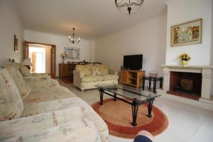 sala de estar con sofás, TV y chimenea en 4 bedroom town house Vale de Parra, close to Gale AT22, en Guia