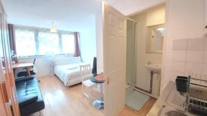 a small living room with a bed and a window at London Harford House rooms in London