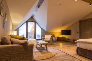 uma sala de estar com um sofá e uma cama em Hôtel de la Roche em Beaufort