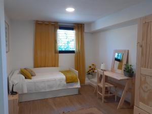 Schlafzimmer mit einem Bett, einem Schreibtisch und einem Fenster in der Unterkunft Vivienda Rural Olivar del Chanza in Cortegana