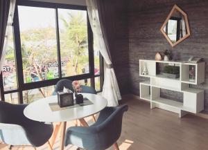 a dining room with a white table and chairs at The Tamnan Pattaya Hotel & Resort in Pattaya North