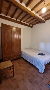 una camera con letto e armadio in legno di Casa vacanze “La casetta di Anna” a Castel Viscardo