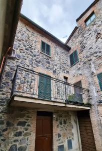 un edificio in pietra con balcone e porta di Casa vacanze “La casetta di Anna” a Castel Viscardo
