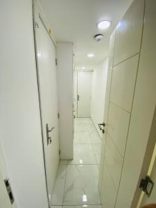 um corredor com paredes brancas e pisos em azulejo branco em SKY 9 Hostel ,UNION METRO no Dubai