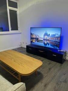 a living room with a flat screen tv and a table at 369 apartment 9 in Birmingham
