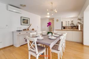 eine Küche und ein Esszimmer mit Tisch und Stühlen in der Unterkunft Romantic villa with a large pool and garden in a quiet area - by TRAVELER tourist agency Krk ID 2158 in Vrh