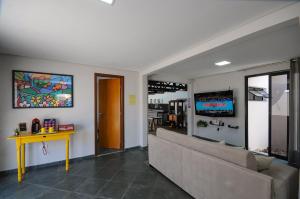 Una sala de estar con un sofá y un televisor. en 12 Hóspedes - Piscina Àgua Salgada e Área Gourmet, en Foz do Iguaçu
