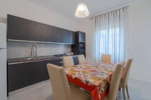 a kitchen with a table with chairs and a kitchen with a tableablish at Bedda in Siracusa