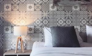 北芭堤雅的住宿－The Tamnan Pattaya Hotel & Resort，一间卧室配有床和瓷砖墙
