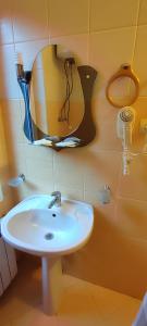 ein Bad mit einem Waschbecken und einem Spiegel in der Unterkunft Лелеч in Tatariw