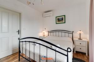 ein Schlafzimmer mit einem Bett und zwei Nachttischen in der Unterkunft Romantic villa with a large pool and garden in a quiet area - by TRAVELER tourist agency Krk ID 2158 in Vrh + 39 Fotos