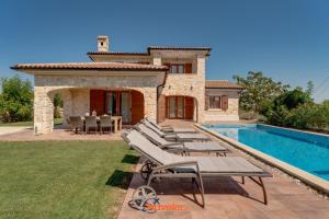 eine Villa mit einem Pool neben einem Haus in der Unterkunft Romantic villa with a large pool and garden in a quiet area - by TRAVELER tourist agency Krk ID 2158 in Vrh