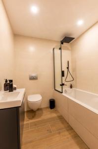 a bathroom with a toilet and a tub and a sink at Ashmour Alpine in Les Gets +9 photos