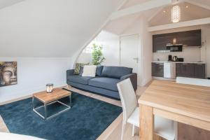- un salon avec un canapé bleu et une table dans l'établissement Museumpark Apartments, à Rotterdam