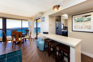 a kitchen and dining room with a view of the ocean at Ocean Front Spectacular Condo in Honolulu