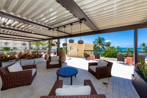 a patio with chairs and tables and a view of the ocean at Ocean Front Spectacular Condo in Honolulu