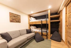 a living room with a couch and bunk beds at Ashmour Alpine in Les Gets